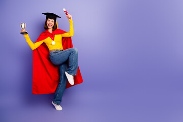 Young chic graduate celebrates success with trophy and diploma in a bright purple studio