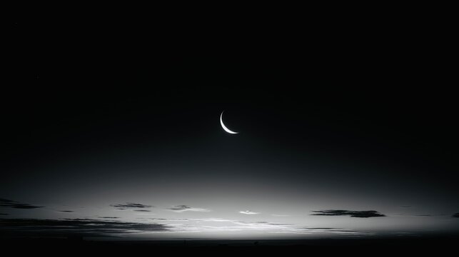 Crescent moon over calm horizon in minimal night sky