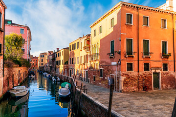 romantic view of a canal in Venice with boats and blue water and beautiful vintage buildings around the cityscape © Yaroslav