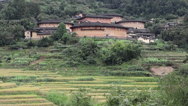 View landscape of Nanjing Terraced rice fields farming and Nanjing Tulou Hakka Houses earth building on mountain for chinese people travelers travel visit in Shuyang town of Zhangzhou in Fujian, China