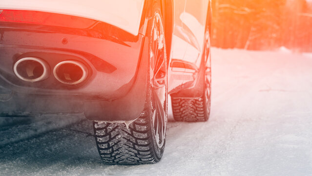 Modern car on winter studded tires in the woods on a snowy road. High quality photo