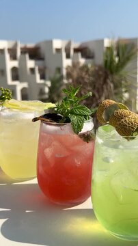 Assortment of five colorful tropical cocktails at a luxury resort in Egypt. Variety of refreshing summer drinks with exotic garnish on a sunny poolside terrace.