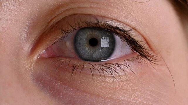 Close-up of female human eye with blue iris and pupil, showcasing gradual changes in focus and light reflection across three sequential frames in a well-lit environment