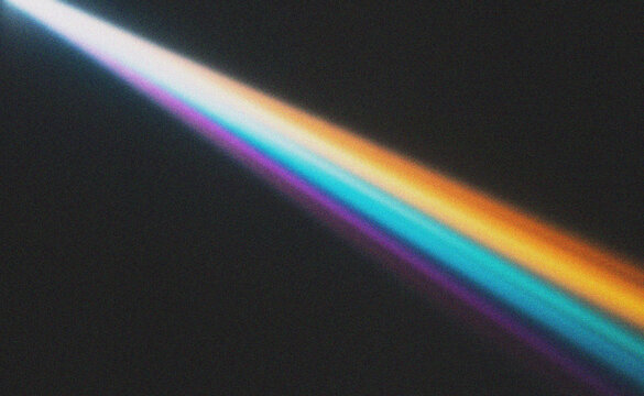 Prismatic Light Ray Beam Across Dark Textured Surface with Vibrant Colors