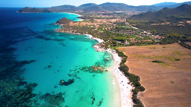 Sardinia Sant Elmo Beach Aerial Drone 4K Video Dynamic Flight Along Rugged Coast with Triangle Spit White Sand and Turquoise Sea Caribbean Style Coastline Italy Mediterranean Scenic Landscape