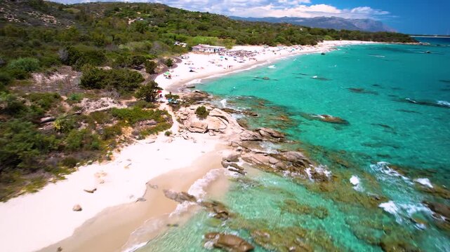 4K Aerial Low Flight Over Sant Elmo Beach in Sardinia. Cinematic Turquoise Caribbean Sea and Granite Rocks with White Sand Coastline. Costa Rei Italy. High Quality 4k Video 