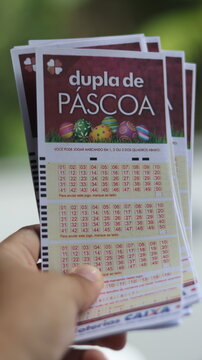 Bilhetes da Dupla Sena de P&aacute;scoa em destaque nas m&atilde;os de apostador, representando participa&ccedil;&atilde;o em sorteio especial da loteria brasileira com expectativa de pr&ecirc;mio elevado. S&atilde;o Paulo em 12 de mar&ccedil;o 26