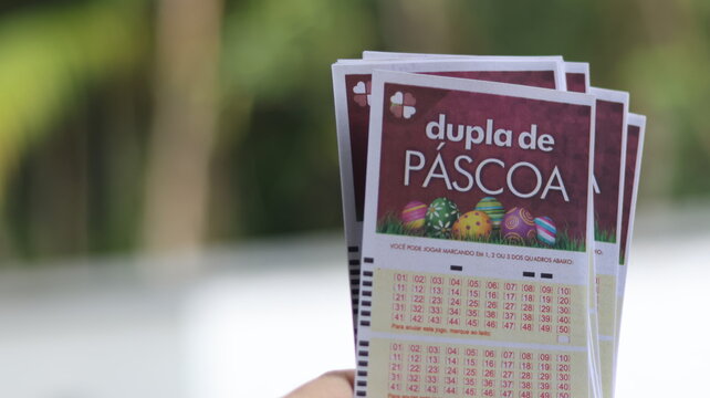 M&atilde;o segurando bilhetes da Dupla Sena de P&aacute;scoa, loteria especial brasileira que costuma pagar pr&ecirc;mios milion&aacute;rios em sorteio anual realizado no per&iacute;odo de P&aacute;scoa. S&atilde;o Paulo em 12 de mar&ccedil;o de 2026
