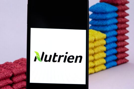 Nutrien company logo displayed against a background of fertilizer bags. Nutrien is an American producer and marketer of crop nutrients and fertilizers.