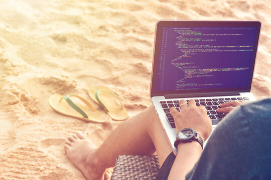 A programmer typing source codes at the beach in a relaxing working environment. Studying, Working, Technology, Freelance Work Concept.