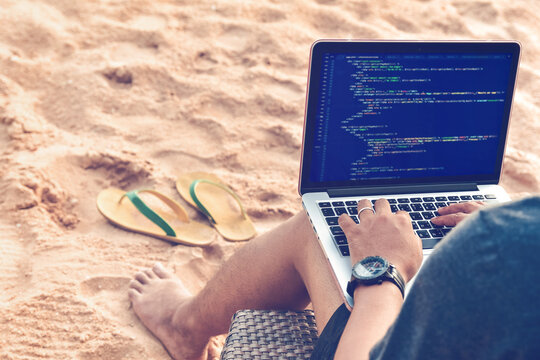 Digital Nomad Programming on Beach with Laptop and Flip Flops.