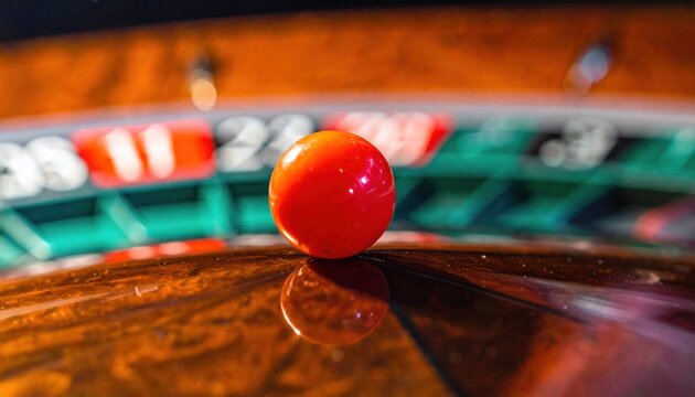 A single red roulette ball poised for a roll on a casino table, symbolizing luck and anticipation.