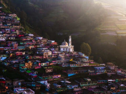 Aerial view of a vibrant village nestled amidst terraced fields, dominated by a central mosque with a golden dome, Nepal van Java, Jawa Tengah, Indonesia.
