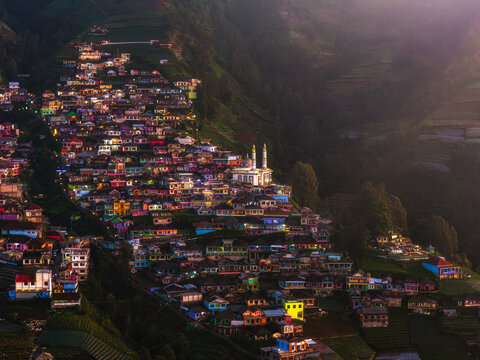 Aerial view of colorful houses clustered like jewels on the slopes, dominated by a central white mosque, Nepal van Java, Jawa Tengah, Indonesia.