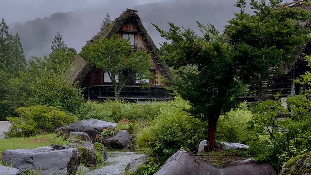 4K Cinematic video of traditional Gassho-zukuri house in Shirakawa-go with rainy atmosphere and sound of flowing water