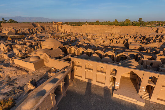 Aerial view of the historic Arg-e Bam citadel ruins basking in the warm glow of the setting sun, its mud-brick structures standing as silent witnesses to time, Bam, Kerman Province, Iran.