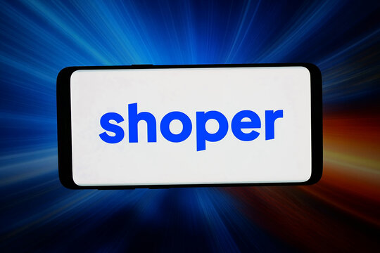 Stuttgart, Germany - 03-10-2026: In this photo illustration, the logo of Polish e-commerce company Shoper S.A. is displayed on a smartphone in front of abstract background on computer screen.