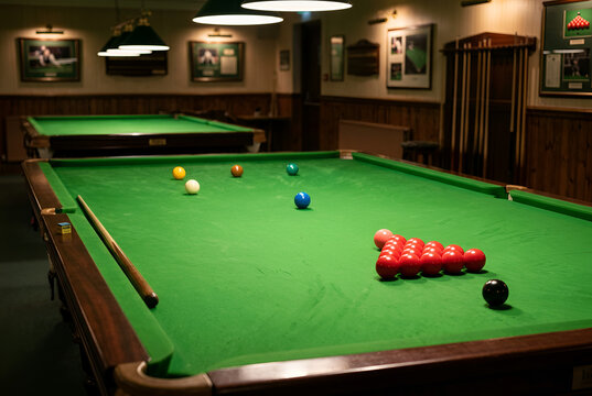 A close-up view of a beautifully crafted pool table with vibrant green felt, featuring colorful billiard balls ready for a game, Snooker player hand, cue, and balls before shot

