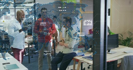 Discussing team clustering by desk in open office in business casual, glass partition map overlay