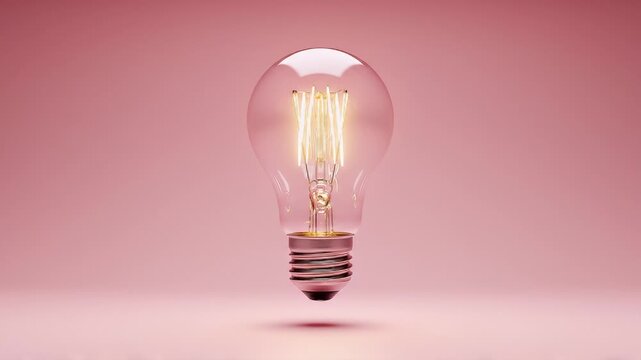 Illuminated Vintage Edison Light Bulb Glowing with Warm Light on a Soft Pink Background, Symbolizing Ideas and Inspiration