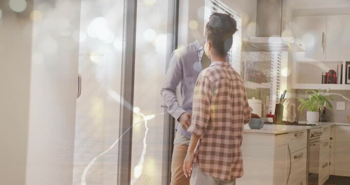 Woman approaching man causing man reaching for mug placing arm around her sharing calm home bokeh