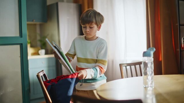 Little pupil packing backpack with notebooks study materials water bottle.