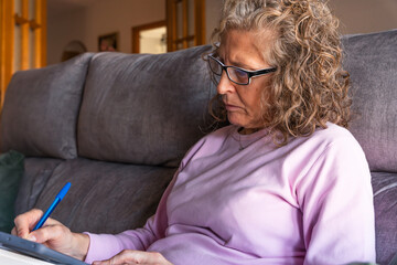 Woman working remotely with smartphone from sofa
