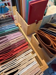 Leather goods showcase with various wallets, cardholders, and material swatches in a retail setting