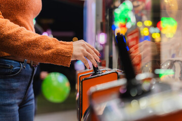 Person's hand operating a joystick at an arcade game at the park at night © pablo