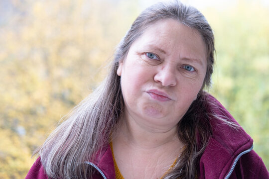 skeptical woman narrows eyes, expression filled with doubt in natural setting, raised eyebrow and tight lips convey skepticism in intimate nature portrait, unexpected doubts, mistrust