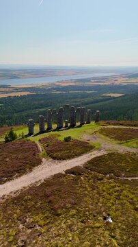 Aerial Cinematic View of Fyrish Monument Surrounded by Purple Blooming Heather in the Scottish Highlands.