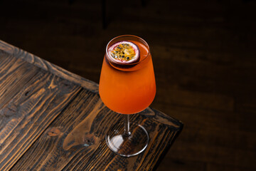 Drink served in a tall glass sits on a wooden table in a dimly lit space during the evening hours © Serega