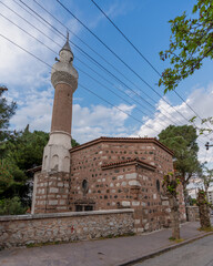 Meteorites Mosque, or Goktasli Cami, a traditional stone and brick mosque with a tall minaret, under a blue sky with clouds and power lines in Manisa, Turkey © Khaled El-Adawi