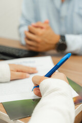 Person signing funeral pre-planning agreement at desk