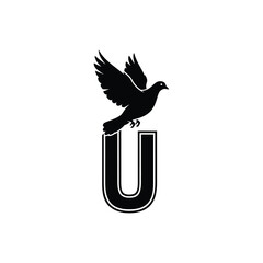 Fototapeta premium Black bird perched on bold letter u flying