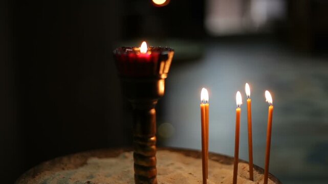 Thin wax candles are burning in the church.