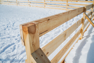Fototapeta premium Geometric Fence Casting Shadows. Snowcovered Ground With Textured Wooden Fence. Minimalist Scene Showing Timber Fence Shadows On Smooth Snow With Detailed Grain And Angled Joints