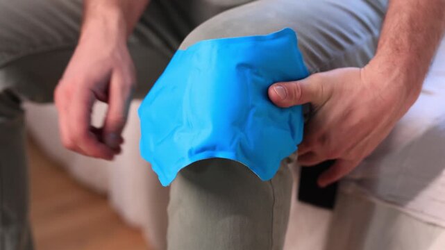 Man at home holding painful injured knee.