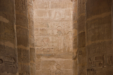Ancient Egyptian Temple Reliefs and Hieroglyphs Between Massive Stone Columns