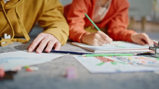 Dad son hands drawing pencils lying home carpet closeup. Happy dad little boy