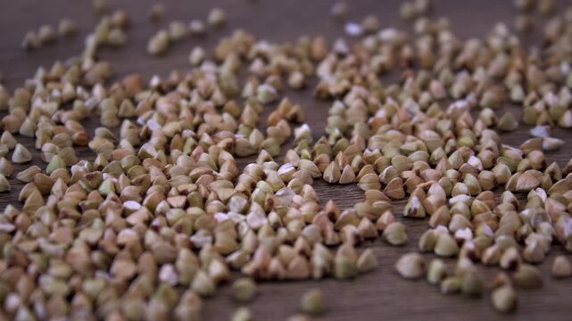 Raw buckwheat groats (Fagopyrum esculentum). Macro shot of buckwheat grains on a wooden surface
