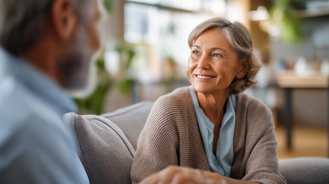 Wide bright template visualization of a mental health and grief support consultation space for elderly patients a therapist visible from the side beside a senior patient on