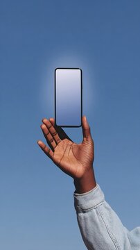 Smartphone tenuto in mano da un uomo, contro uno sfondo azzurro cielo.