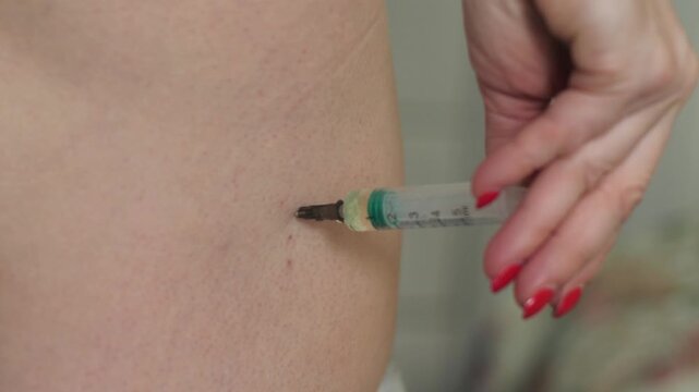 Close up of the intramuscular injection process into the buttock. Self-administration of a drug using a syringe at home