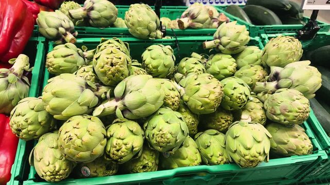 Artichoke displayed on a market counter. The fresh green artichokes are neatly arranged, highlighting their natural texture and seasonal appeal in the shop.