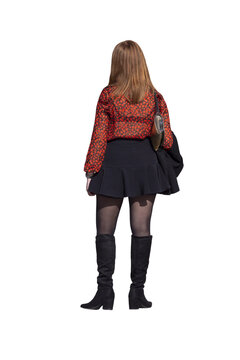 Femme vue de dos debout, blouse rouge &agrave; motifs, jupe courte noire &eacute;vas&eacute;e, collants noirs, bottes hautes noires, sac bandouli&egrave;re, posture droite et attitude naturelle