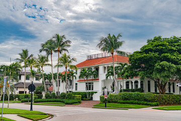 Fototapeta premium Luxury tropical house with palm trees and red tile roof in Naples Florida residential neighborhood