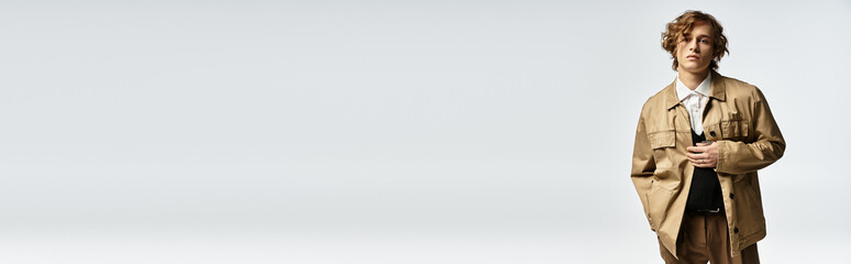 Stylish handsome man in a modern fashion outfit stands confidently against a minimalist backdrop © LIGHTFIELD STUDIOS