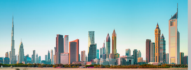 Panoramic skyline of Dubai with modern skyscrapers and futuristic architecture at sunset. Iconic...