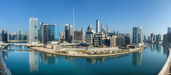 Naklejka premium Panoramic skyline of Dubai with modern skyscrapers and futuristic architecture at sunset. Iconic cityscape of the largest city in the United Arab Emirates, famous for luxury tourism, business district